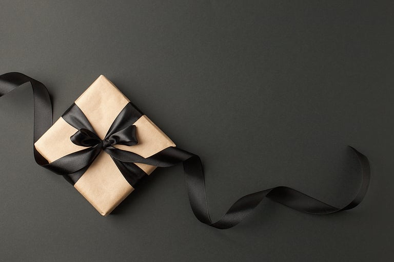 Craft gift box on a dark background, decorated with a textured bow and feathers, creating a romantic luxury atmosphere. For birthday, anniversary presents, gift post cards.