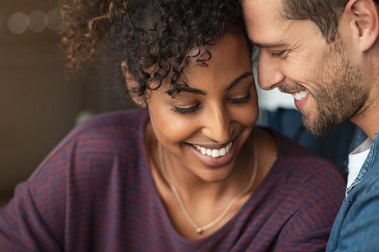 Portrait of attractive couple embracing each other. Closeup loving multiethnic couple embracing and kissing. Closeup face of cheerful boyfriend and african girl cuddling in love at home.