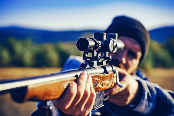 Hunter with Powerful Rifle with Scope Spotting Animals. Hunter with shotgun gun on hunt. Hunter in the fall hunting season