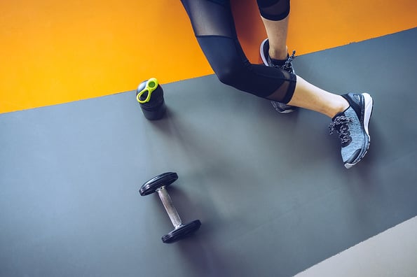 Woman excercise workout in gym fitness breaking relax holding apple fruit after training sport with dumbbell and protein shake bottle healthy lifestyle bodybuilding Top view