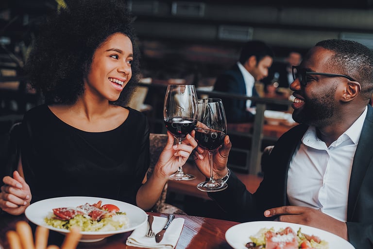 African American Couple Dating in Restaurant. Romantic Couple in Love Dating. Cheerful Man and Woman with Menu in a Restaurant Making Order. Romantic Concept. Cheers Classes Red Wine.