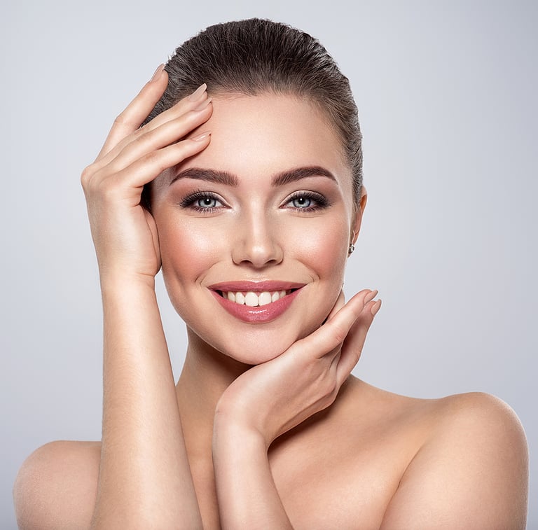 Beauty face of the young beautiful smiling woman with a fresh healthy skin. Closeup portrait of an attractive caucasian female. Skin care concept. Woman with a smokey eye makeup. Beauty treatment.