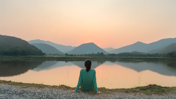 women sitting at bank of river
