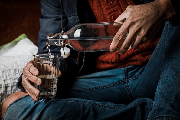 Alcohol problem. A man holds a bottle of alcohol in his hand. Problem with alcohol addiction, alcoholism