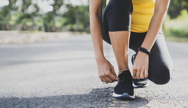 smartwatch Running shoes runner woman tying laces for autumn run in forest park. Runner trying running shoes getting ready for run. Jogging girl exercise motivation heatlh and fitness