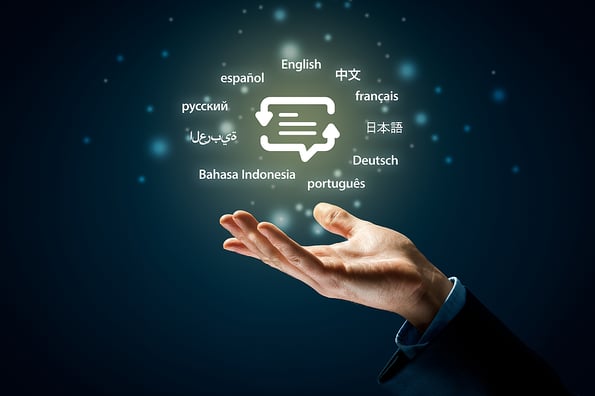 Translator professional and languages education concepts. Hand with symbol of translation (speech bubble with arrows and abstract text) and globally important languages.