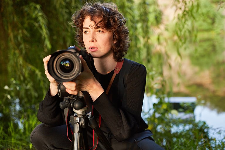 Young photographer with camera and tripod as nature photographer or wildlife photographer