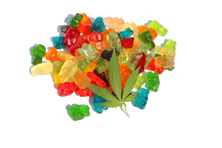 THC Edibles. Gummy Candies filled with CBD or THC. Isolated on white. Room for text. Marijuana Leaf on Candy.