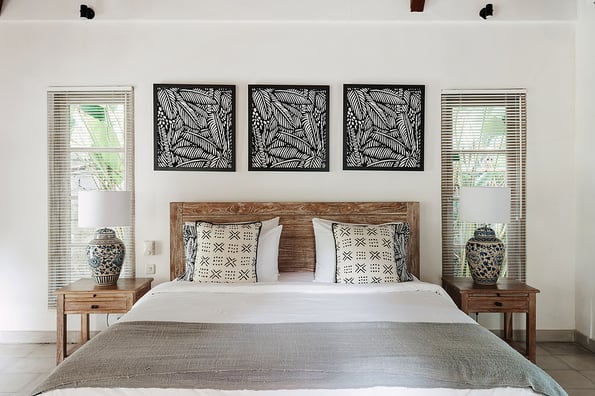 White authentic interior in comfortable bedroom with large cozy bed, night stands and elegant lamps inside beautiful house or hotel room