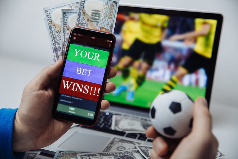 Smartphone with betting mobile application and males hand with soccer ball. Sport and betting concept