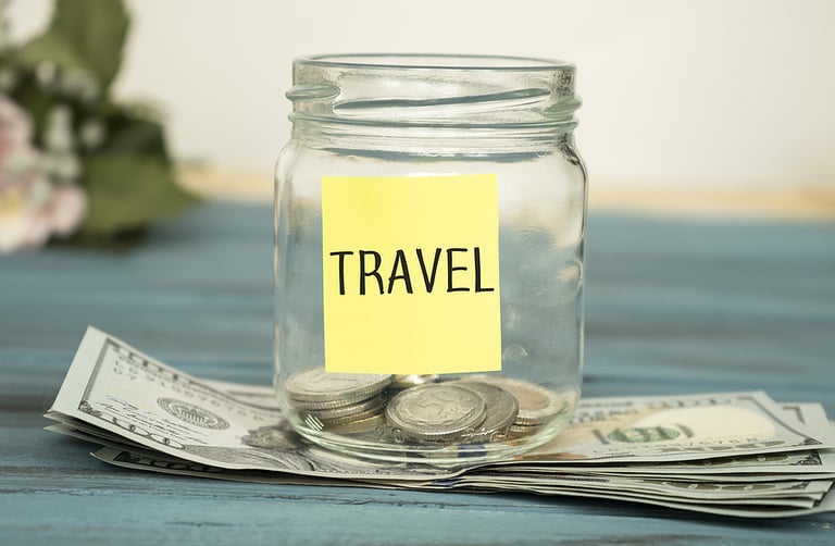 Travel budget - vacation money savings in a glass jar on world map. Travel budget concept. Money saved for vacation in glass jar on world map background, copy space. Banknotes and coins for adventure
