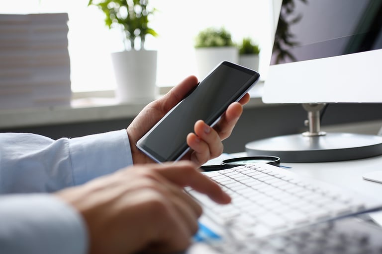 Businessman hipster holds telephone background of computer keyboard in office clodeup. Make transaction money mobile wallet cryptocurrency payment for goods services remote access management concept
