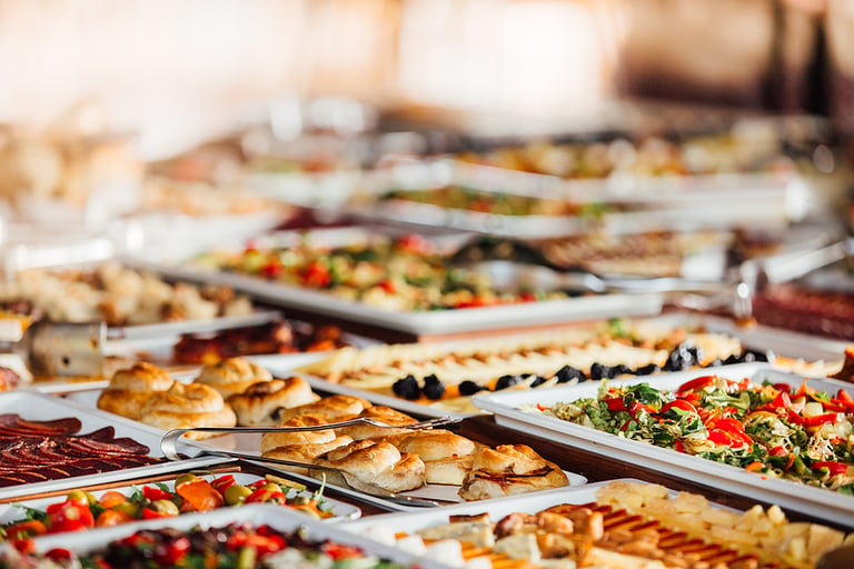 Elegant serving dishes and food warmers with various meals served for catering wedding reception in a hotel or restaurant. Buffet served by the catering service company.Appetizers in elegant serveware