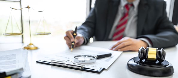 Male lawyer or judge working with contract papers, Law book and wooden gavel on table in courtroom, Justice lawyers at law firm, Law and Legal services concept.