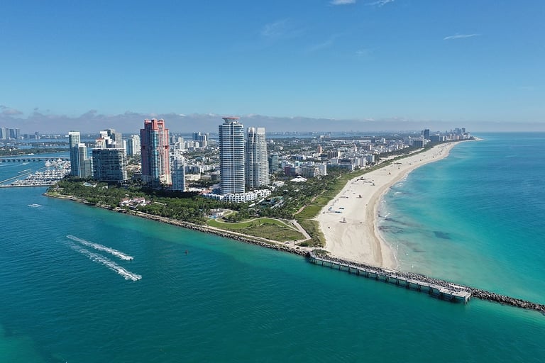 Aerial view of South Pointe Park and South Beach in Miami Beach, Florida with Port Miami and City of Miami skyline in background.