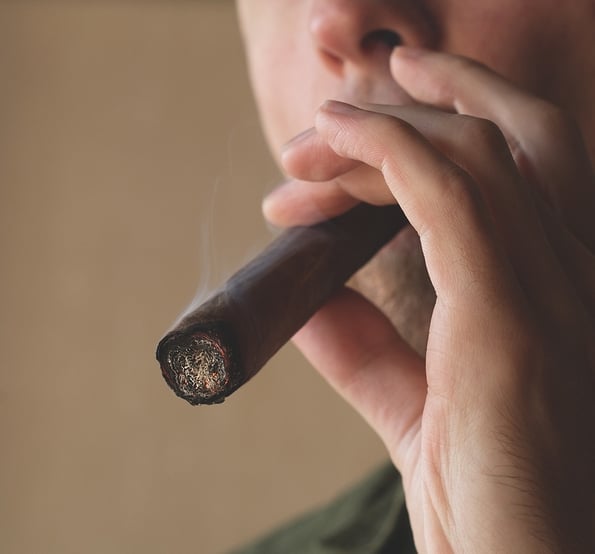 A man smokes a Cuban cigar. Close-up of a smoking cigar.