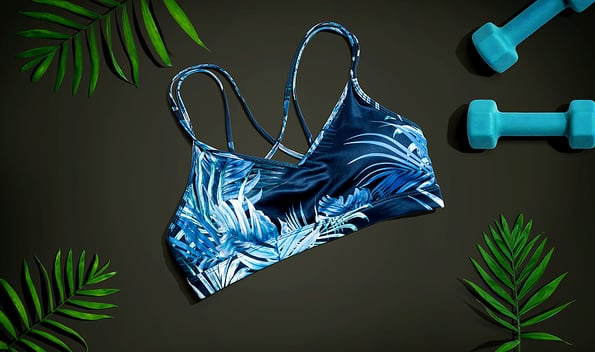 Fitness theme with dumbbells and sports bra - flat lay