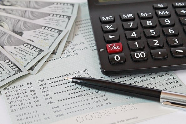 Business, finance, saving money, banking, loans, investment, taxes money planning or accounting concept : American dollars cash money, calculator and pen on saving account book or financial statement