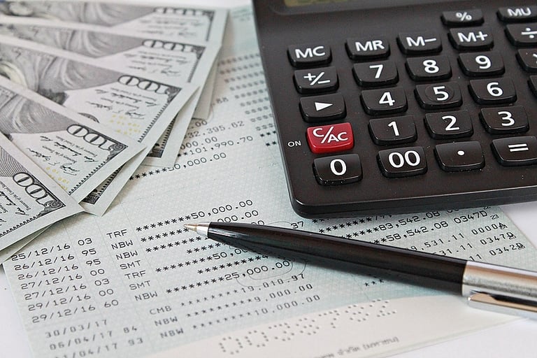 Business, finance, saving money, banking, loans, investment, taxes money planning or accounting concept : American dollars cash money, calculator and pen on saving account book or financial statement