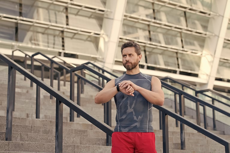 Great progress. Staying fit and healthy. checking his watch while jogging in the morning. Running man with smart watch. Handsome fitness man using smart watch. muscular sportsman looking at device
