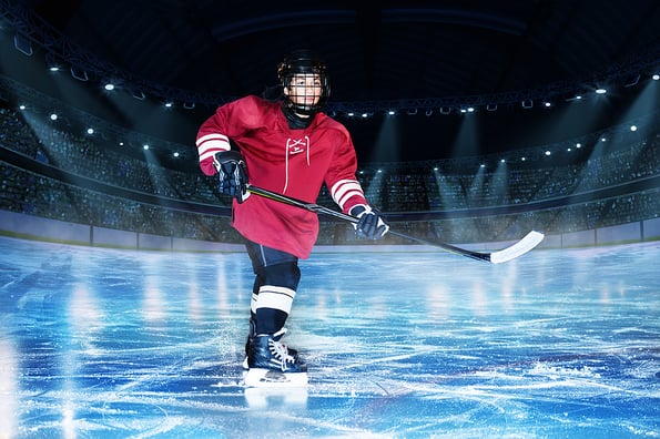 Hockey player with stick on the rink of ice arena
