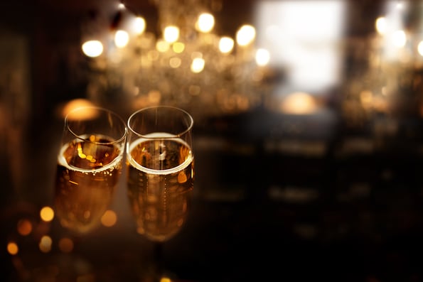 New year celebration with sparkeling champagne. Festive new year's eve background with golden bokeh and space for text.