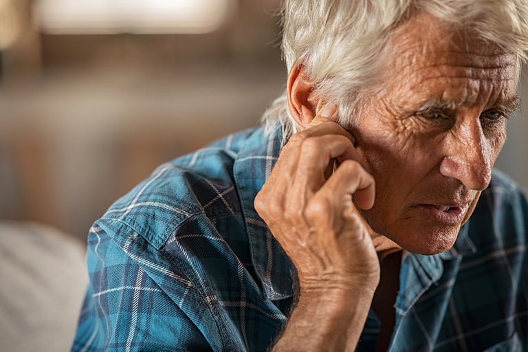Senior man holding ears while suffering from pain. Tensed mature man holding ears. Side view of senior man with symptom of hearing loss, copy space. Retired man with fingers near ear suffering pain. hearing loss.