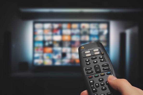 VOD service on television. Man watching TV, streaming service, video on demand, remote control in hand. subscription services