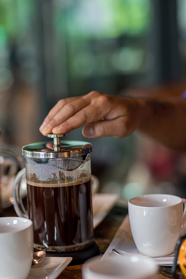 Hand preparing coffee in French Press Coffee Maker. Morning concept. coffee siphon. Spent coffee break at the organic cafe and prepare Chocolate or tea in French press.