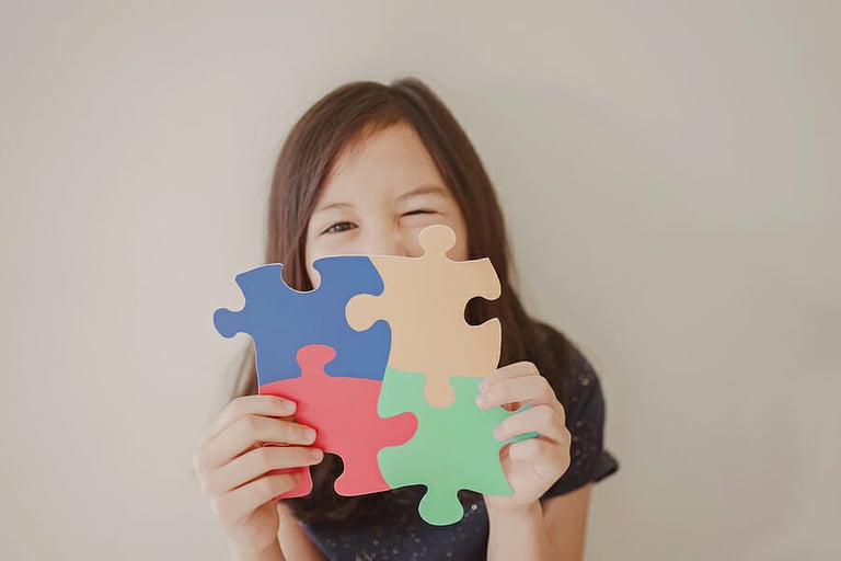 Young girl holding puzzle jigsaw, child mental health concept, world autism awareness day, autism spectrum disorder awareness concept