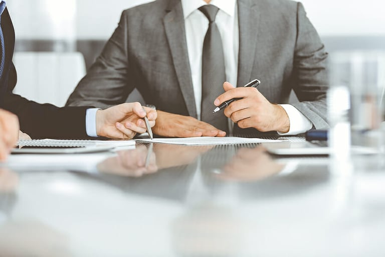 Unknown business people working together at meeting in modern office, close-up. Businessman and woman with colleagues or lawyers discussing contract at negotiation