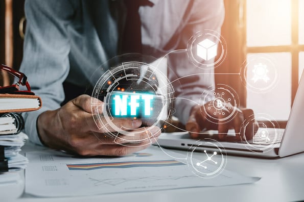 NFT token digital crypto art blockchain technology concept, Person hand using smartphone with NFT icon on virtual screen.