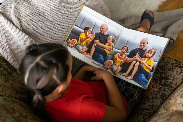 a little girl is holding a photo book