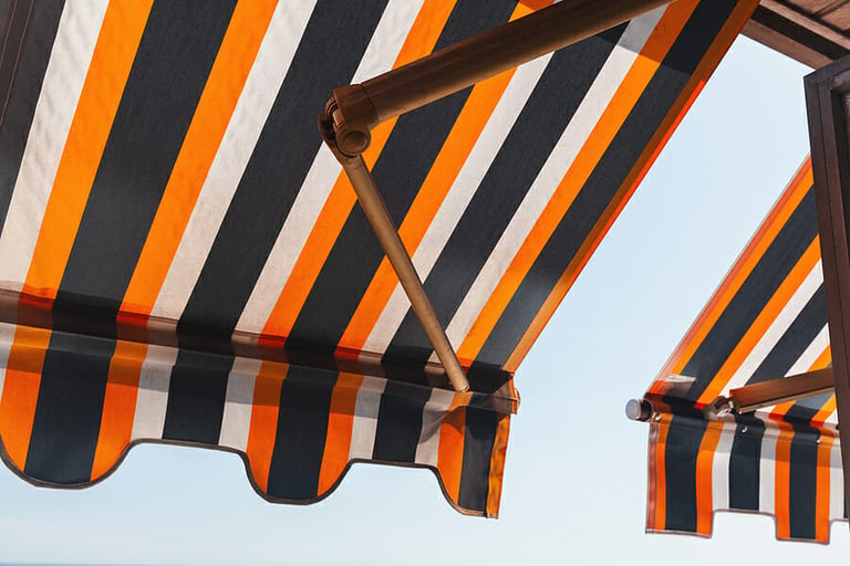 Folding patio balcony awning, side sun shade under bright summer sky