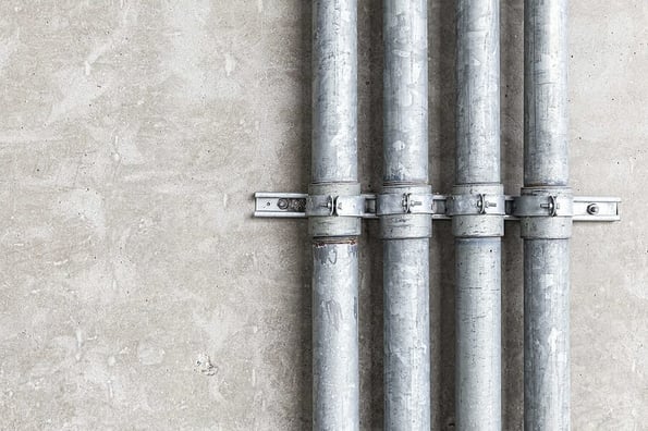 Steel conduit box and pipes installed on white cement wall