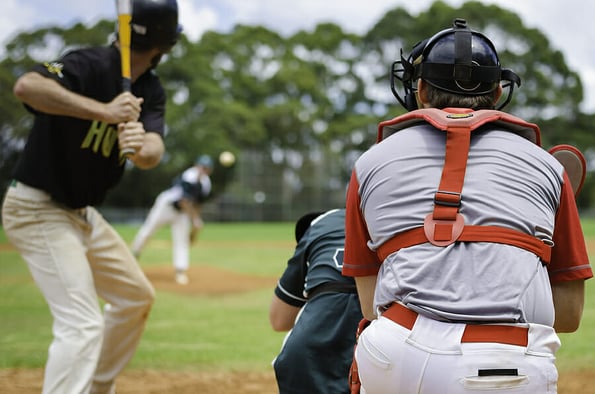 Baseball pitcher throwing ball to batter watched by Umpire and Catcher.