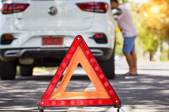 Car breakdown on road. Car broken down with red emergency stop sign warning triangle on the road.nYoung man maintenance, fixing car accident repair on street. mechanic open car hood checking car engine.