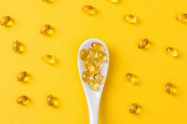 Close up of oil filled capsules on spoon suitable for: fish oil, omega 3, omega 6, omega 9, vitamin A, vitamin D, vitamin D3, vitamin E