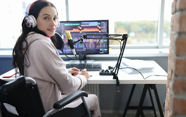 Disabled woman works as radio presenter in wheelchair in studio. Cybersport for disabled people concept