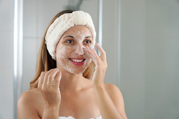 Skincare woman washing face foaming soap scrubbing skin. Face wash exfoliation scrub soap woman washing scrubbing with skincare cleansing product. Enjoying relaxing time.