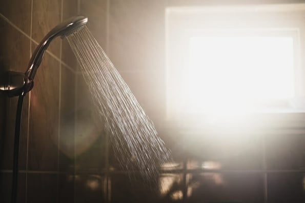 shower with flowing water and steam with window on background.