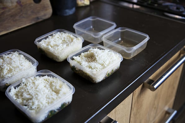 Meal prep. Stack of home cooked rice and chicken dinners in containers ready to be frozen for later use as quick and easy ready meals. Food prepping for healthy dieting