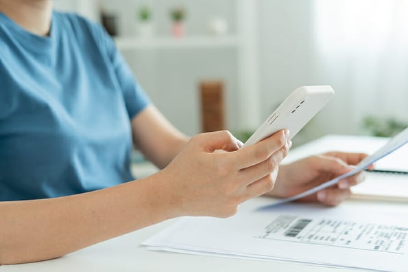 woman use phone scan barcode or QR codes to pay credit card bill after receiving document invoice. payment, receive, paying electricity, digital payments, technology, scanning, financial transaction