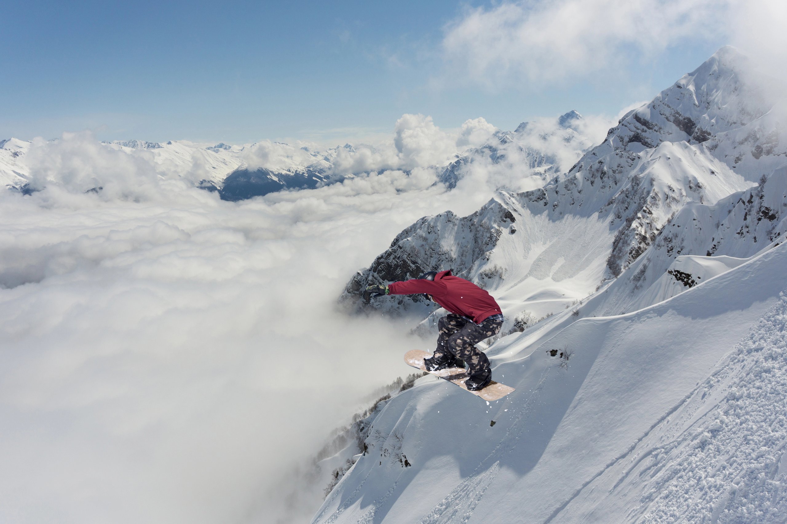 Extreme winter sport. Snowboarder jumping in snowy mountains.