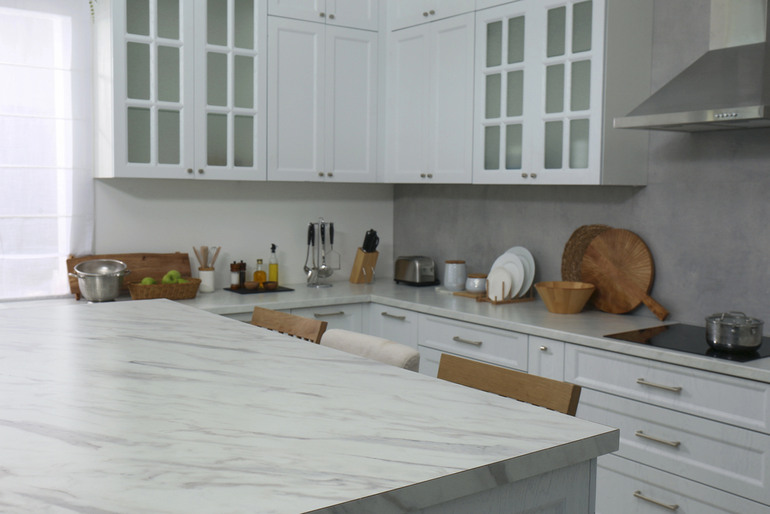 Updated Atlanta kitchen with painted cabinets, warm natural lighting, open wood shelving, modern backsplash, and budget-friendly design upgrades without a full renovation.