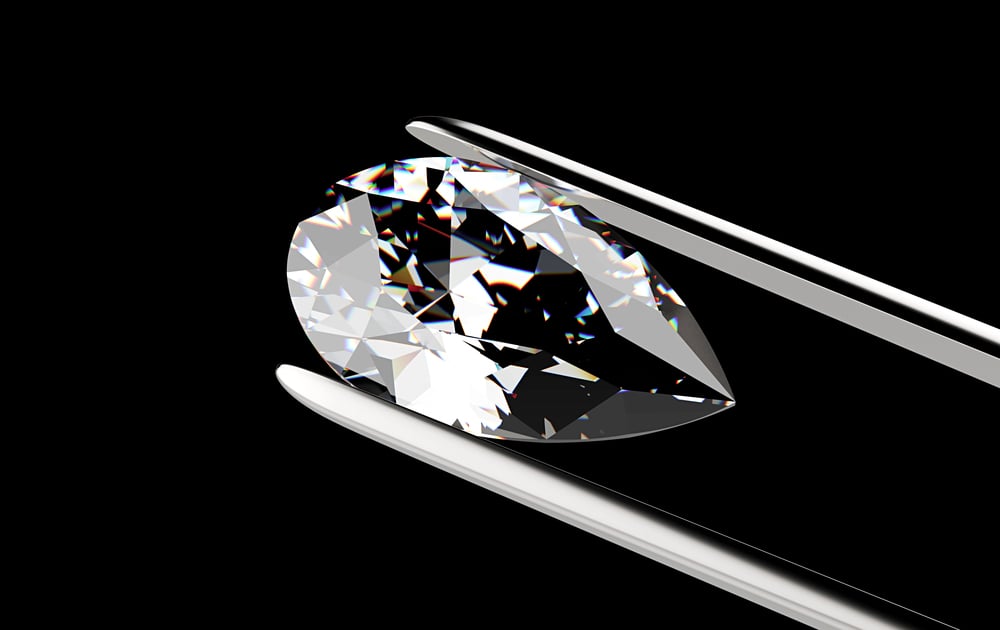 Diamond in a tweezer against a solid black background