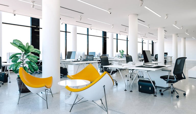 Modern open-plan office with ergonomic workstations, lounge seating, and spacious layout designed to reduce workplace noise and improve employee focus.