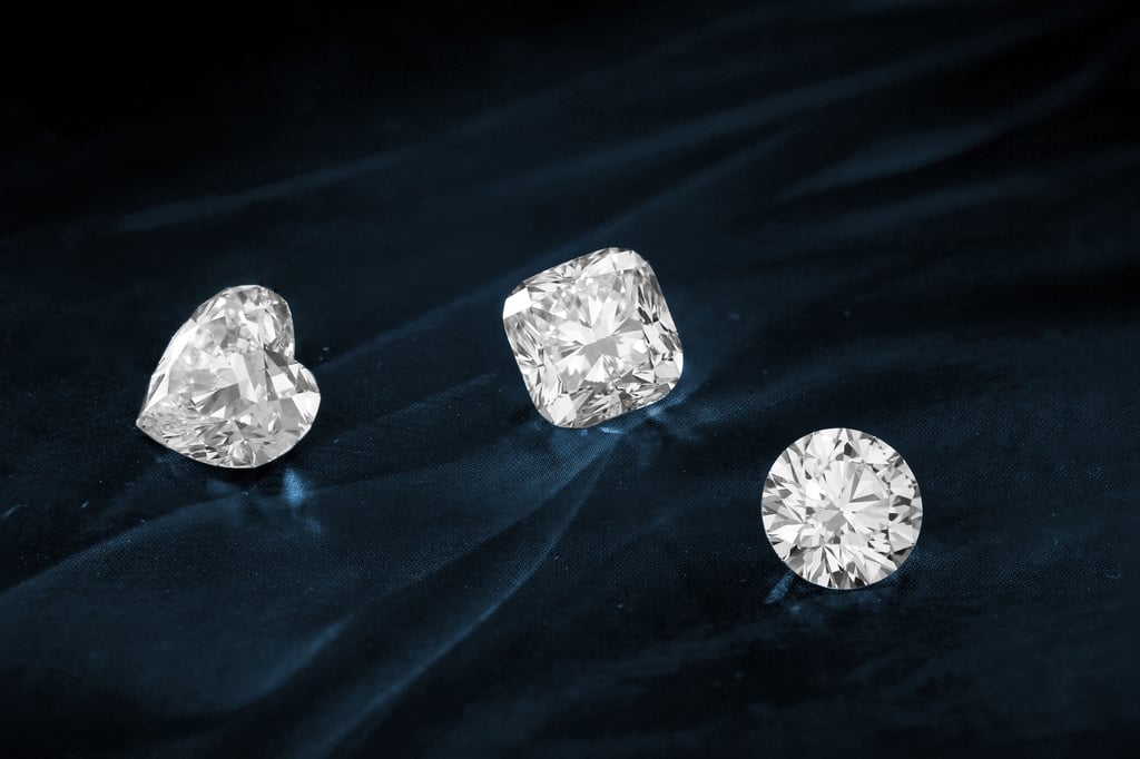 A heart diamond, a square diamond, and a round diamond on a black background