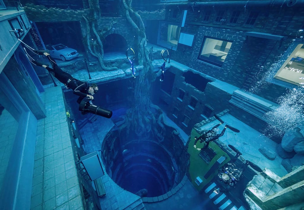 A diver exploring the underwater city in Deep Dive Dubai
