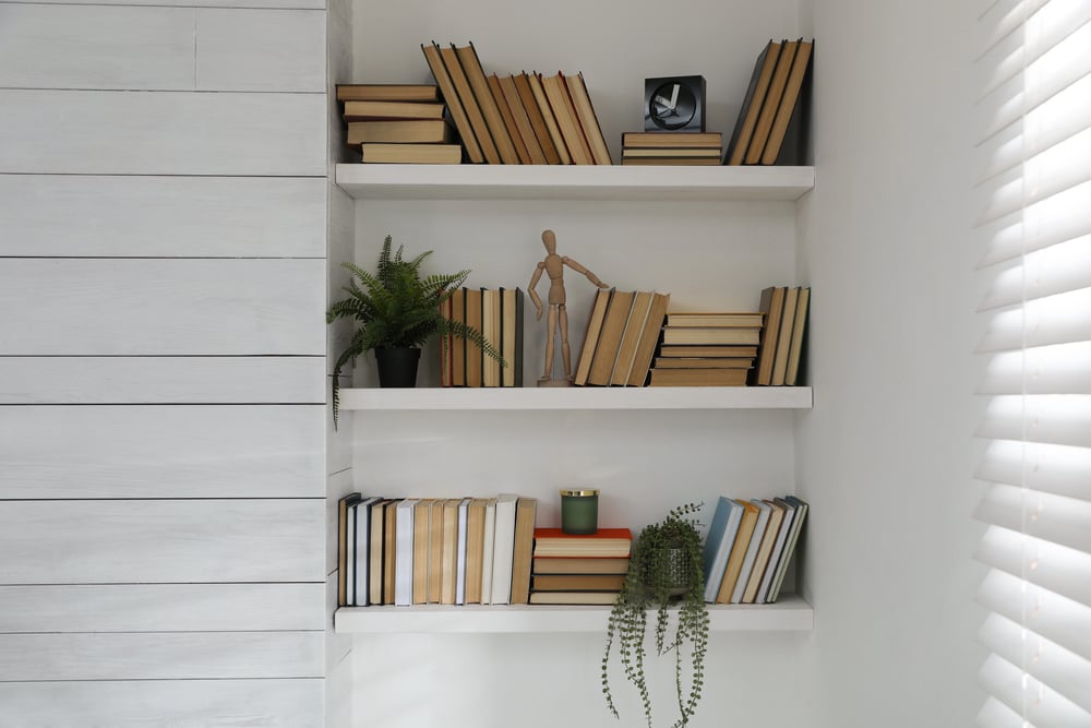 Built-in white wall bookcase holding books and decorative objects